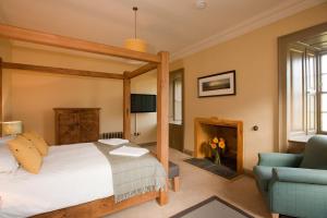 a bedroom with a bed and a chair and a fireplace at Balnakeil House in Balnakeil