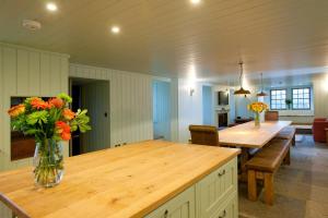 a kitchen with a table with a vase of flowers on it at Balnakeil House in Balnakeil