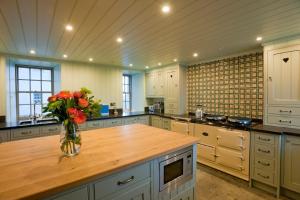a large kitchen with a vase of flowers on a counter at Balnakeil House in Balnakeil