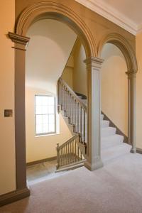 an arched hallway with a staircase in a house at Balnakeil House in Balnakeil