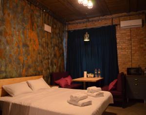 a bedroom with a bed and a table with chairs at Apartment Arena City Loft in Kyiv