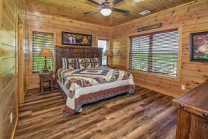 um quarto com uma cama num chalé de madeira em SmokyStays 10 Bedroom Cabin em Pigeon Forge
