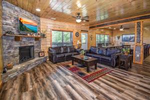a living room with leather furniture and a fireplace at SmokyStays 10 Bedroom Cabin in Pigeon Forge