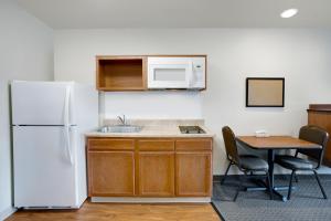 uma cozinha com um frigorífico branco e uma mesa em WoodSpring Suites Manassas Battlefield Park I-66 em Manassas