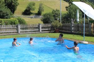 a group of children playing in a swimming pool at Gasserhof Garni & Apartment in Schenna