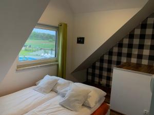 a small bedroom with a bed with a window at Apartmenty Magnolia in Łeba +93 photos
