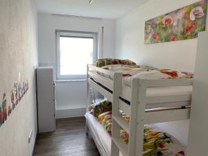 a bedroom with two bunk beds and a window at Frankenwaldwohnung in Stockheim Oberfranken