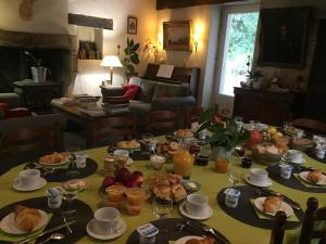 een tafel met eten in de woonkamer bij La Maison des Gardes - Chambres d'hôtes in Cluny