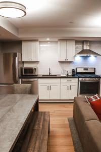 a kitchen with white cabinets and a couch at The George in Montclair