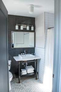 ein Bad mit einem Waschbecken und einem Spiegel in der Unterkunft The George in Montclair