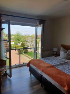 a bedroom with a bed and a large window at Ferienwohnung Warnemünde - Landhaus Immenbarg in Diedrichshagen