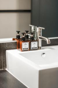 a bathroom sink with two bottles of soap on it at The George in Montclair