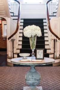 a table with a vase with white flowers on it at The George in Montclair