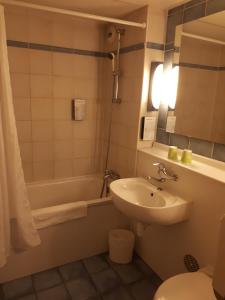 een badkamer met een wastafel, een toilet en een bad bij Campanile Rodez in Rodez