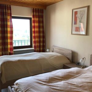 a hotel room with two beds and a window at Landgasthof Fischer Veri in Mitterfels