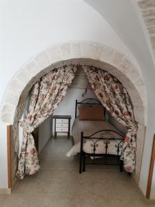a bedroom with an archway with a bed in it at Casa Vacanza Trullo Dimora Storica Morea in Alberobello