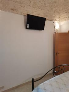 a bedroom with a bed with a tv on the wall at Casa Vacanza Trullo Dimora Storica Morea in Alberobello