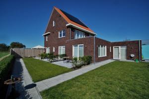 a large brick house with a grass yard at Groede B&B in Groede