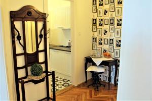a hallway with a kitchen and a table with a chair at Csilla Home Apartman in Miskolc