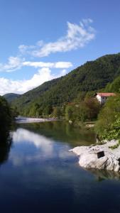 Un río con una casa al lado de una montaña en Rezi, en Slap ob Idrijci