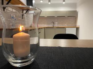 a candle in a glass vase sitting on a table at Apartamenty Centrum in Andrychów