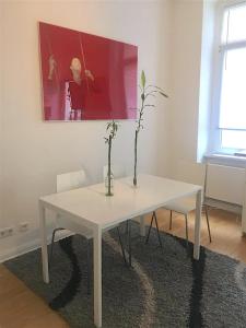 un tavolo bianco con un vaso sopra in una stanza di Apartments near Kurfürstendamm a Berlino