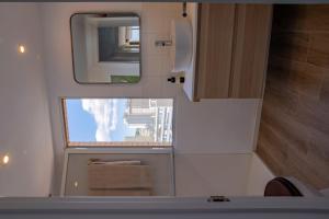 a small bathroom with a mirror and a sink at Apartamento Poniente Beach in Benidorm