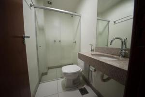 uma casa de banho com um chuveiro, um WC e um lavatório. em Premium Executive Hotel Itabira em Itabira
