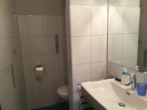 a white bathroom with a sink and a toilet at Ferienwohnung Christel in Wasserburg am Bodensee +15 photos