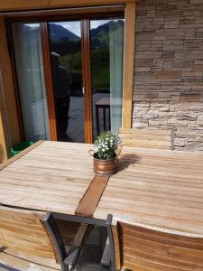 a wooden table with a potted plant on a porch at Chalet Grüneggli in Adelboden
