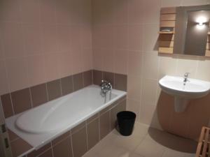 La salle de bains est pourvue d'une baignoire et d'un lavabo. dans l'établissement Magnolia résidence Domaine Cap de Coste, à Saint-Frajou