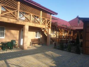 a building with a patio with green chairs and tables at U Yuliyi in Svalyava