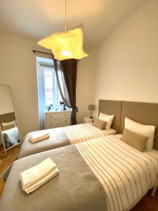 1 Schlafzimmer mit 2 Betten und einem Kronleuchter in der Unterkunft Enjoy Mouraria Apartments in Lissabon