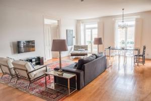 uma sala de estar com um sofá, cadeiras e uma mesa em Eighteen21 Houses - Casa de São Paulo em Lisboa