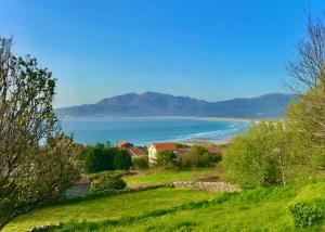 a view of the ocean and a house on a hill at Playa de Carnota - SondeLira in Lira