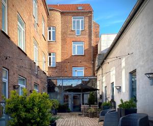 a courtyard with chairs and an umbrella in front of a building at Teaterhotellet in Horsens