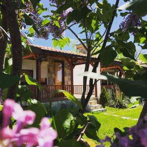a house in the garden with flowers at Karali Apartments in Lagadin