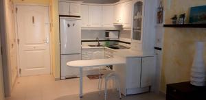 una cucina con armadi bianchi e piano di lavoro bianco di Residence balcon del mar ad Arona
