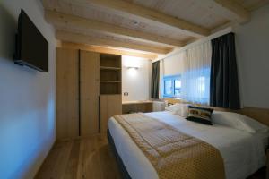 a bedroom with a large bed with a television on the wall at Hotel La Meridiana in Madesimo