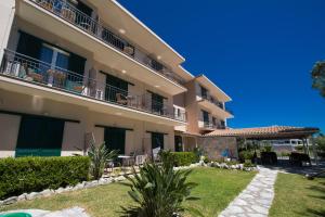 a large apartment building with a lawn in front of it at Marina Pansion in Nydri