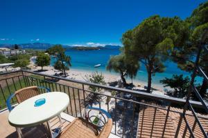 a balcony with a table and chairs and a beach at Marina Pansion in Nydri +30 photos