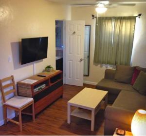 sala de estar con sofá y TV en Blue Heron Cottages en San Diego