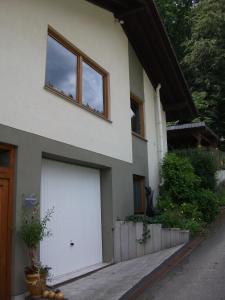 una casa bianca con due porte del garage di En Raußel a Windeck