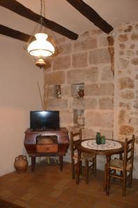 ein Esszimmer mit einem Tisch und einem Fernseher in der Unterkunft Cal Gorro in Arnés