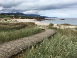 a wooden path leading to a sandy beach at Villa De Foz in Foz
