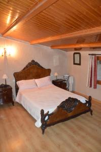 Cette chambre comprend un grand lit avec des draps blancs et du parquet. dans l'établissement Cal Gorro, à Arnés