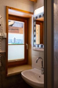 La salle de bains est pourvue d'un lavabo et d'une fenêtre. dans l'établissement Familiengasthof St. Wolfgang, à Spittal an der Drau