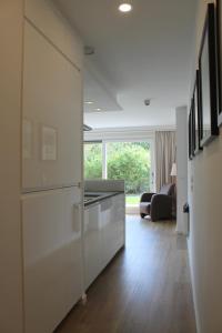 een keuken met witte kasten en een woonkamer bij Appartement HideAway Nr 17 - Amelander Kaap in Hollum