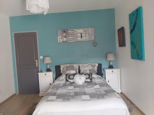 Dormitorio azul con cama con almohada cardiaca en LES ORCHIDEES Ch Hôtes B&B 14 personnes Jaunay-Clan, en Jaunay-Clan