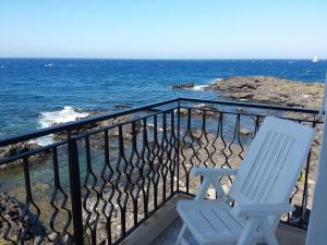 
a wooden bench sitting on top of a beach next to the ocean at Hotel Orpheus in Giardini Naxos
